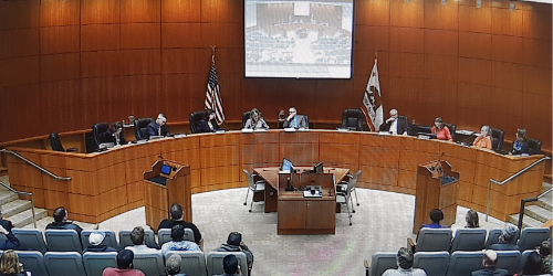 The County Board of Supervisors chamber full of people during a meeting.