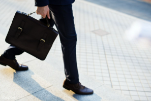 Person walking with a bag in their hand.