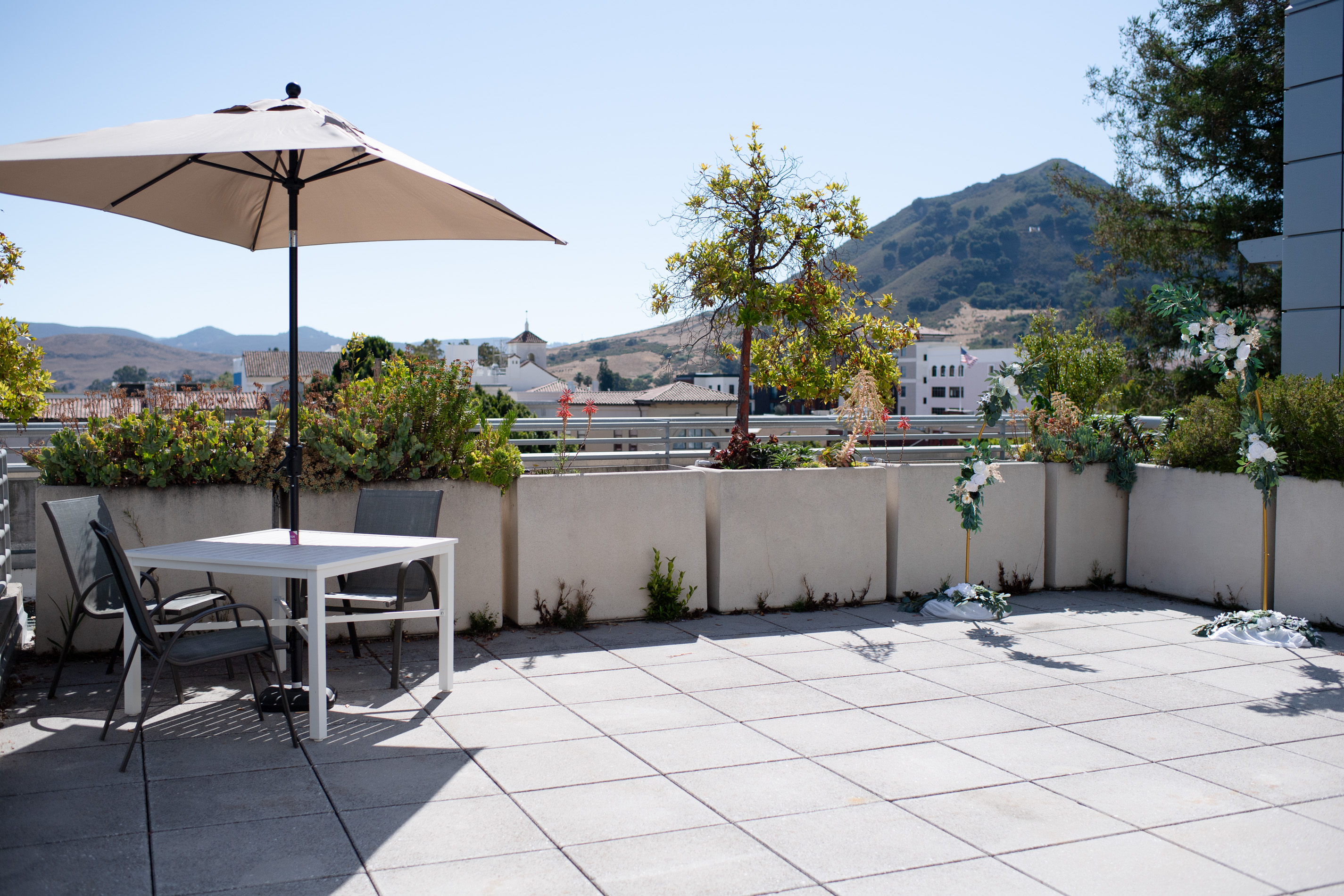 Small table and two chairs with umbrella on rooftop patio