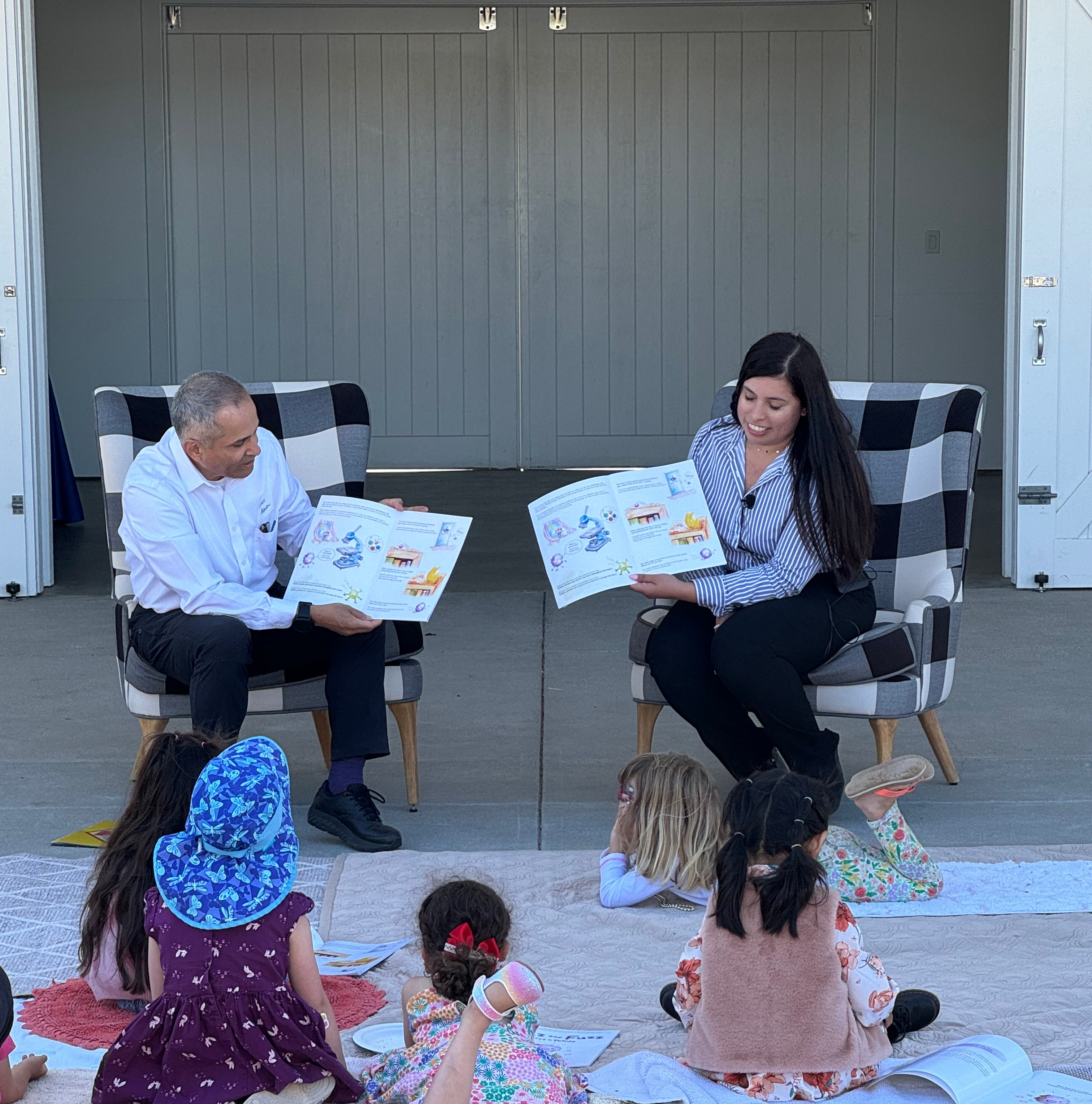 A man and a woman reading to a group of children.