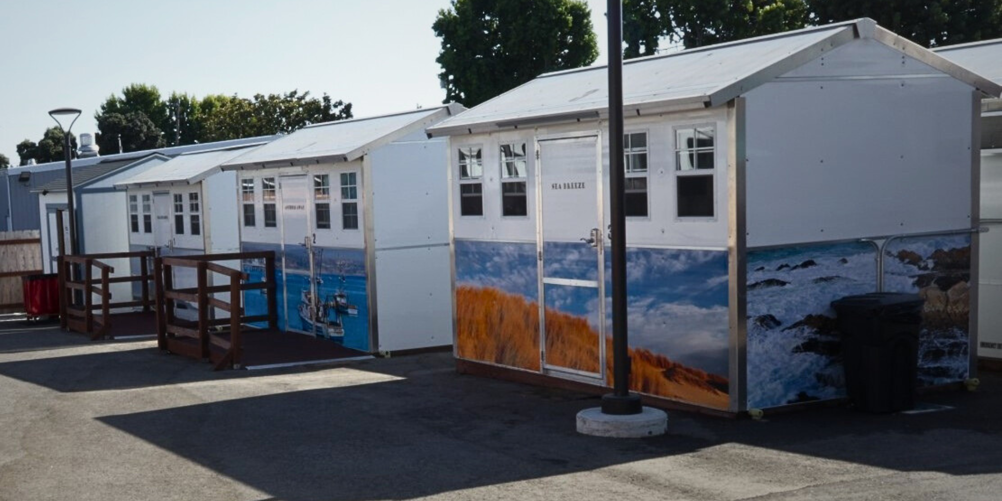 Several prefabricated cabins with decorative ocean murals on their exterior.