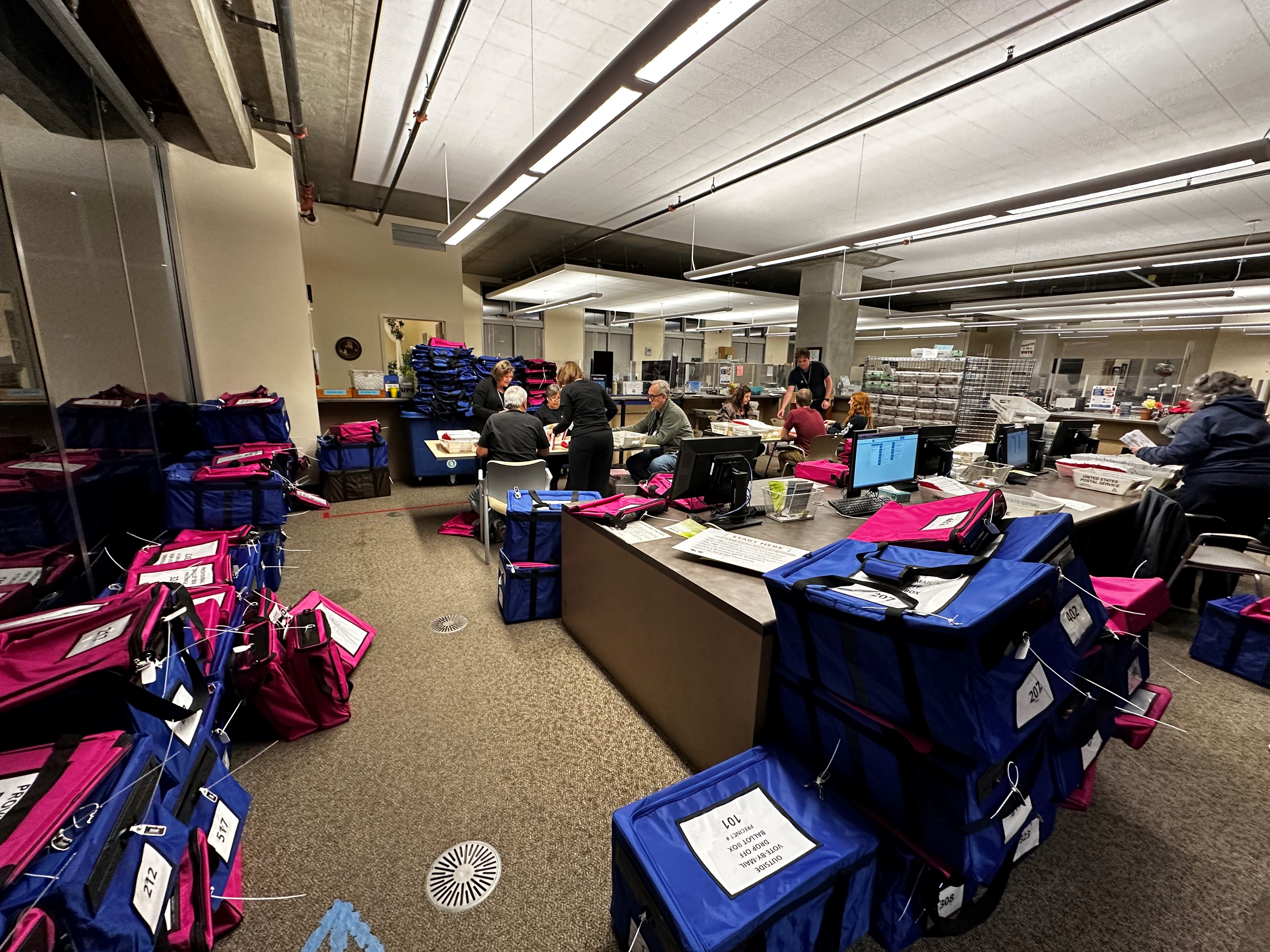 Elections staff empty ballot boxes and document the contents in the lobby of the Clerk-Recorder's Office