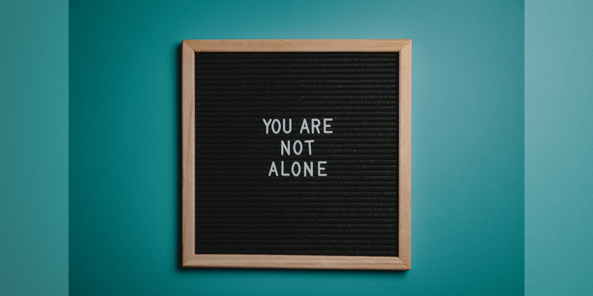 Letter board with text that reads "You Are Not Alone"