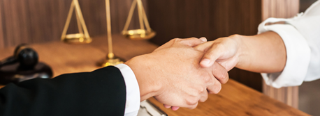 Image of two people shaking hands in court house.